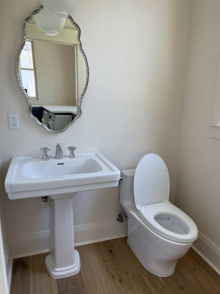 White sink and toilet in 1/2 bath with chrome fixtures